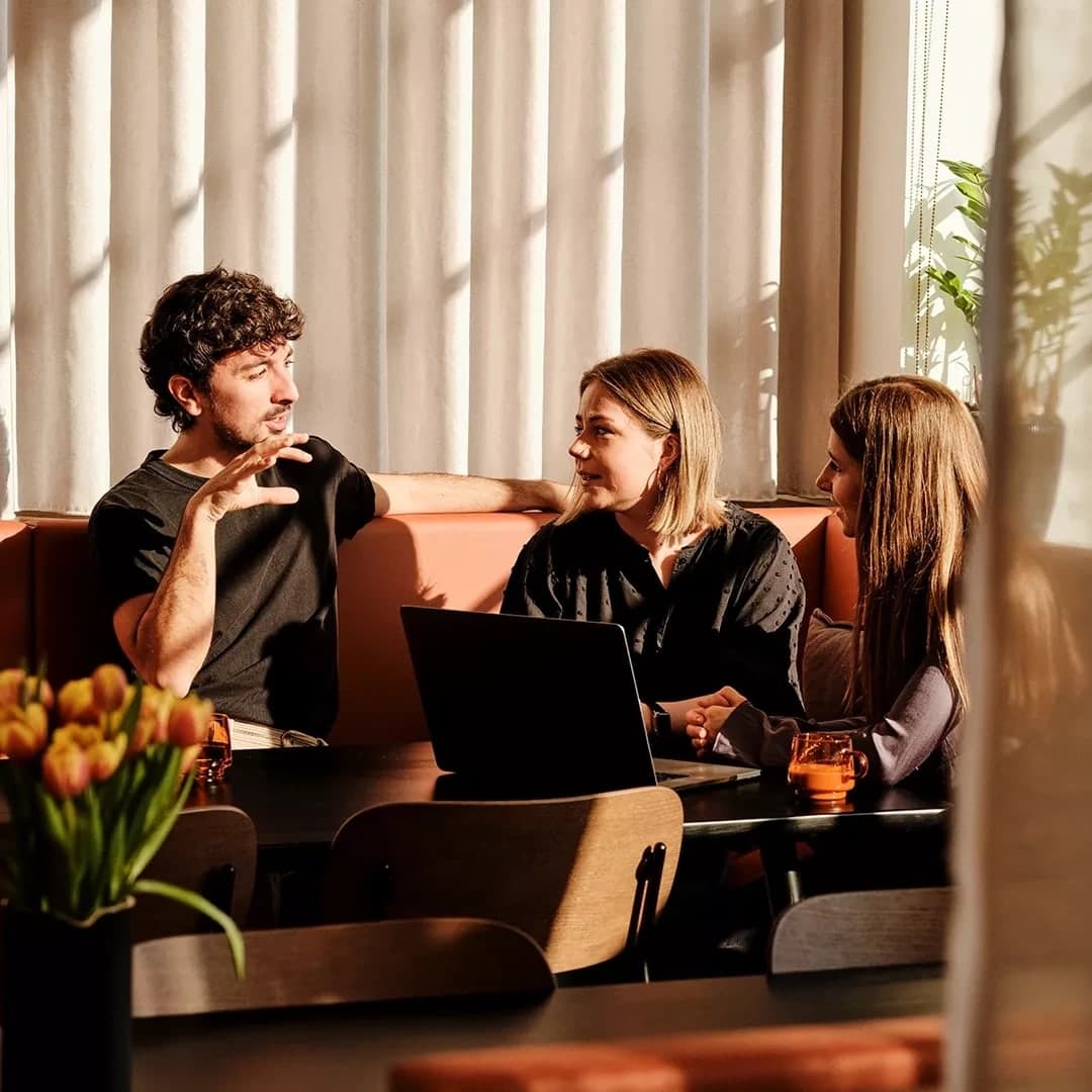 A small team having a conversation around a laptop