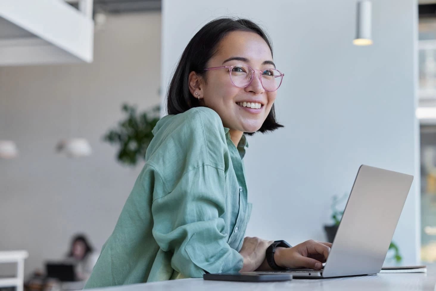 A woman in green working with her laptop